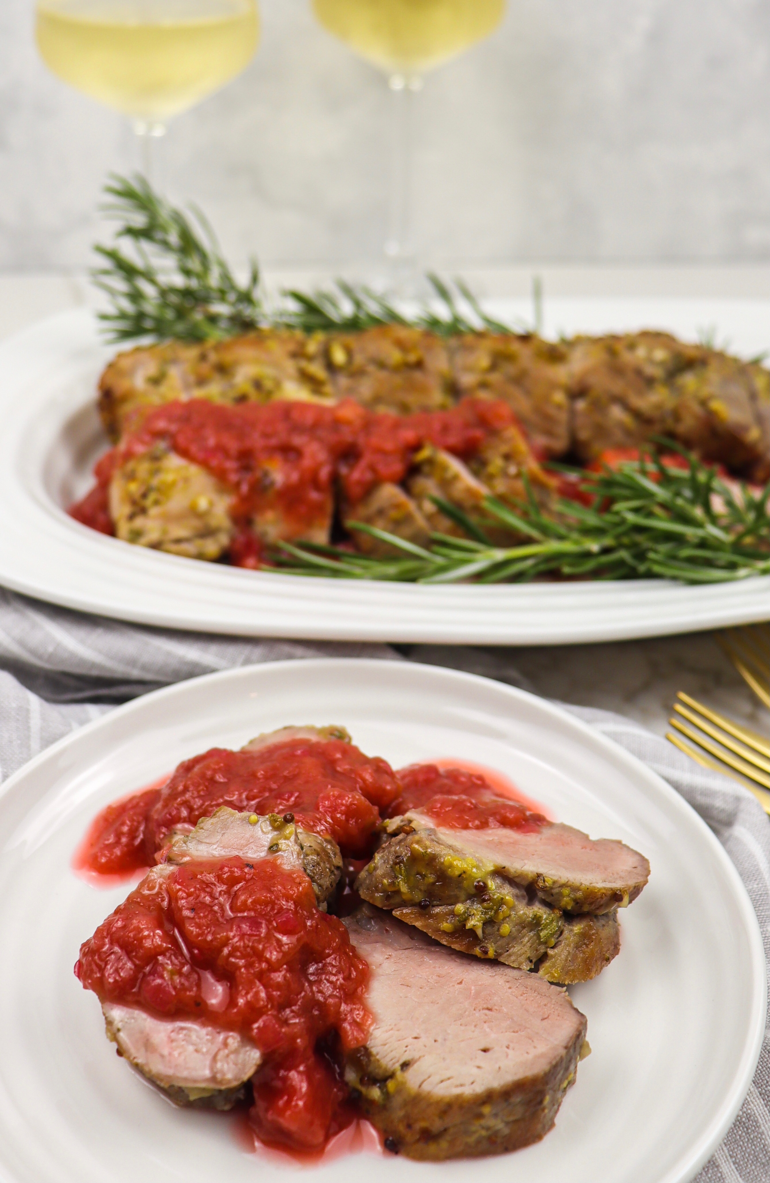 Serving of pork tenderloin with rhubarb compote and pairing of white wine