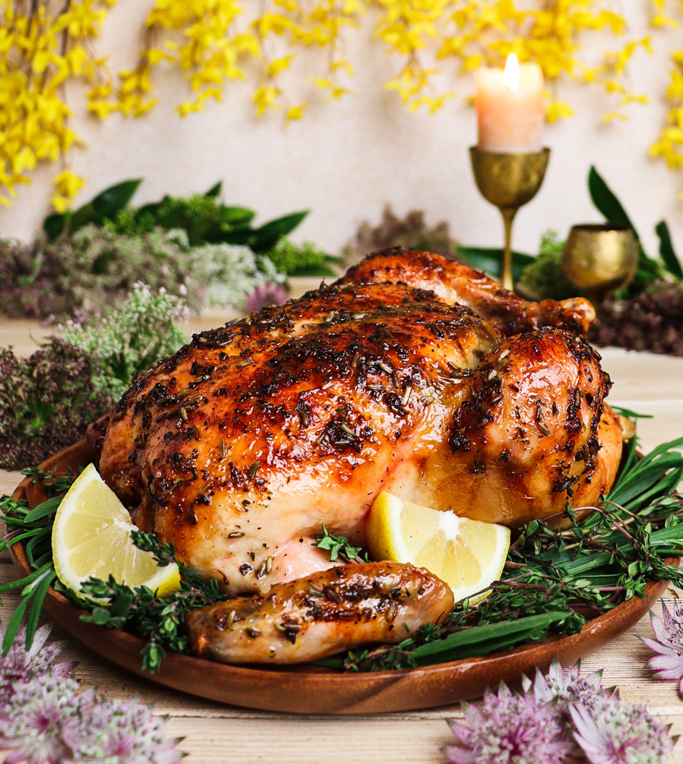 Roast chicken glazed with honey lavender sauce surrounded by yellow flowers and woodland greenery inspired by Lothlórien